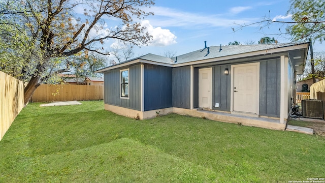 back of house with a lawn and central air condition unit