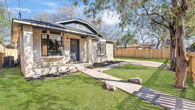 view of front facade featuring a front yard and cooling unit