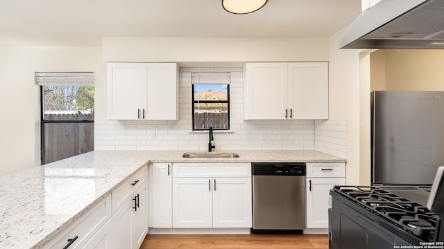 kitchen with white cabinetry, sink, stainless steel appliances, and range hood