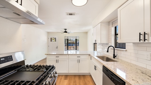 kitchen with white cabinetry, sink, light stone counters, kitchen peninsula, and appliances with stainless steel finishes