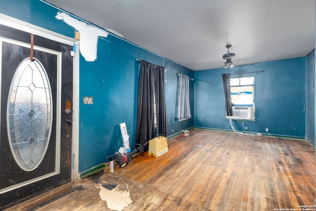 foyer entrance with hardwood / wood-style floors, ceiling fan, and cooling unit