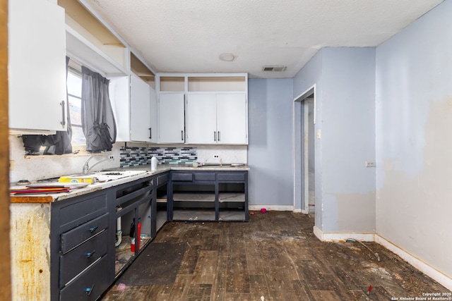 kitchen featuring white cabinetry, sink, dark wood-type flooring, tasteful backsplash, and a textured ceiling