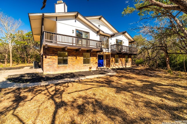 back of property with central AC unit and a deck