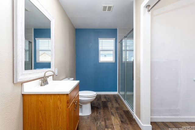 bathroom featuring an enclosed shower, hardwood / wood-style floors, vanity, and toilet