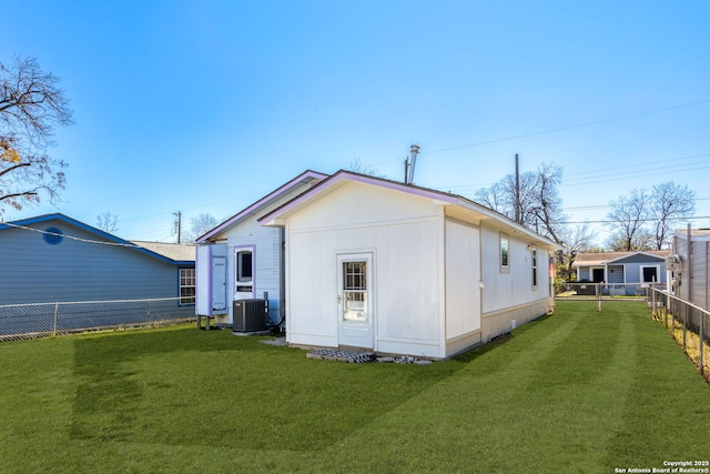 back of property featuring central AC and a yard