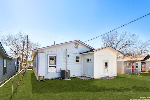 back of house with central AC and a lawn