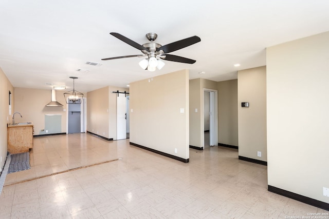 empty room featuring sink, a barn door, and ceiling fan