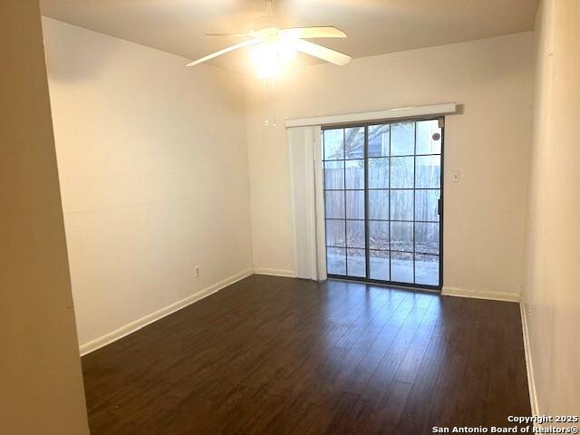 spare room featuring ceiling fan and dark wood-type flooring