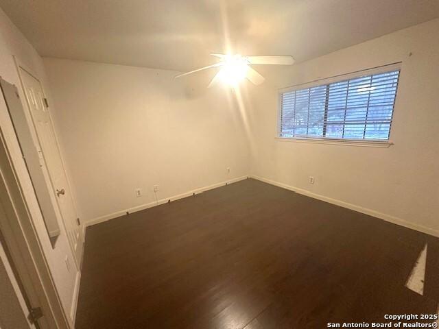 unfurnished room with ceiling fan and dark hardwood / wood-style floors