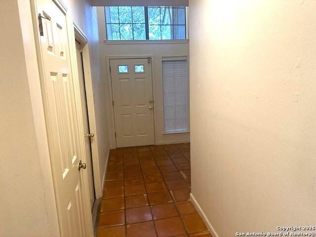 doorway with dark tile patterned floors