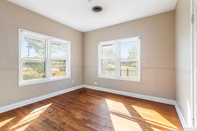 unfurnished room with a wealth of natural light and dark wood-type flooring