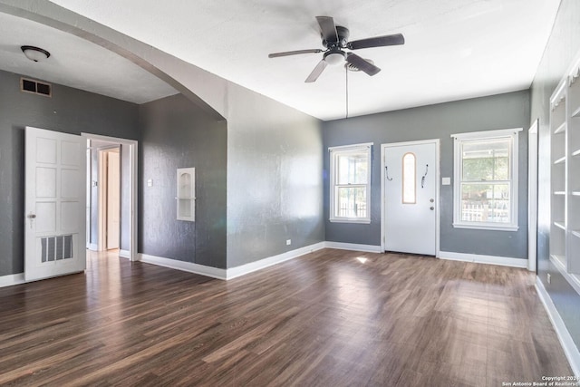 foyer entrance with a healthy amount of sunlight, ceiling fan, dark wood-type flooring, and a textured ceiling