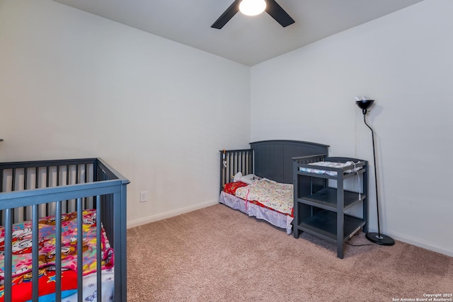 bedroom with ceiling fan, carpet floors, and a nursery area