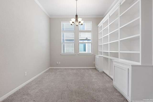 spare room with a chandelier, light colored carpet, and ornamental molding