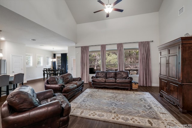 living room featuring dark hardwood / wood-style flooring, high vaulted ceiling, and ceiling fan