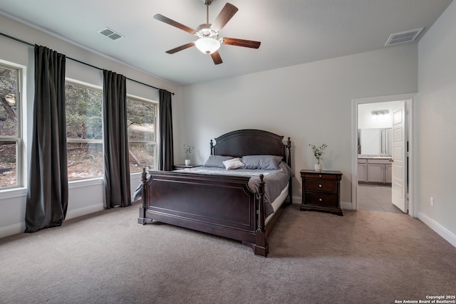 bedroom featuring ensuite bathroom, ceiling fan, and light colored carpet