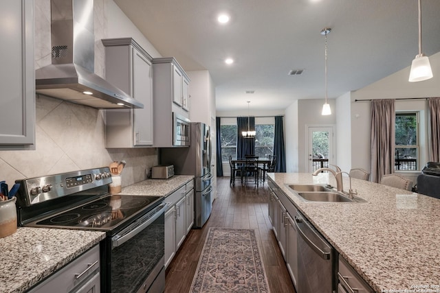 kitchen featuring decorative light fixtures, stainless steel appliances, tasteful backsplash, and wall chimney exhaust hood