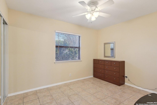 unfurnished bedroom with ceiling fan and a closet