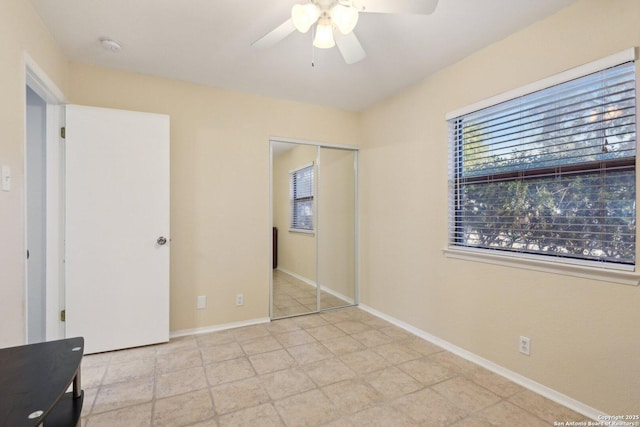 unfurnished bedroom with ceiling fan and a closet