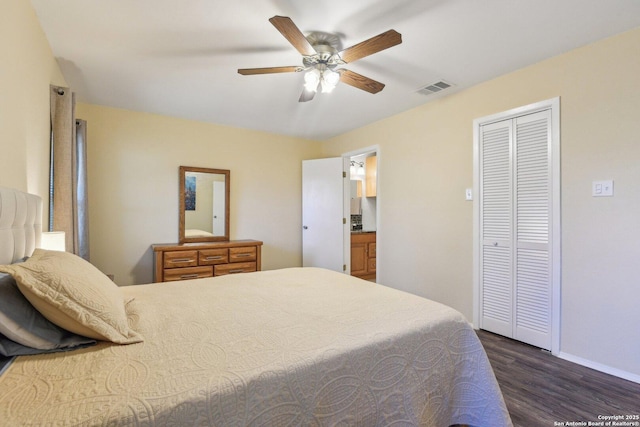 bedroom featuring a closet, dark hardwood / wood-style floors, ceiling fan, and connected bathroom