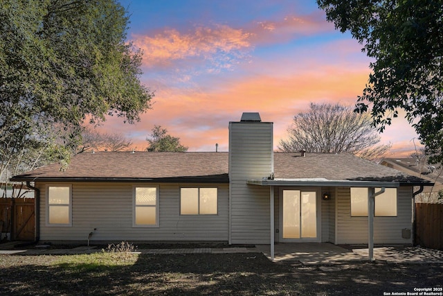 back house at dusk featuring a patio