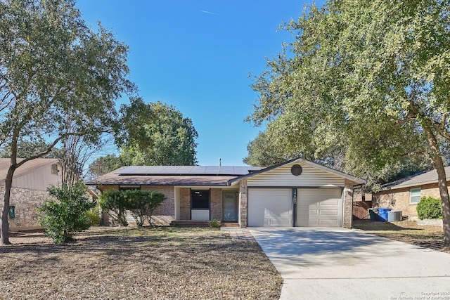 ranch-style home with solar panels and a garage