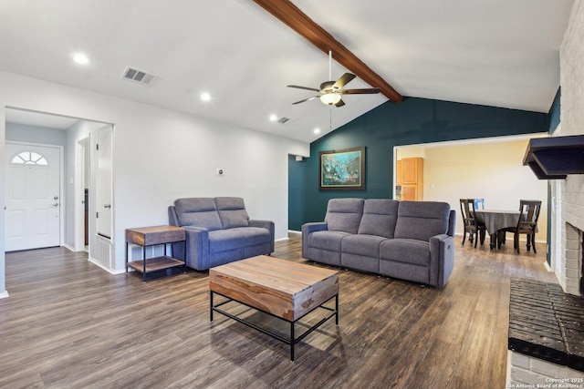 living room featuring ceiling fan, lofted ceiling with beams, dark hardwood / wood-style floors, and a brick fireplace