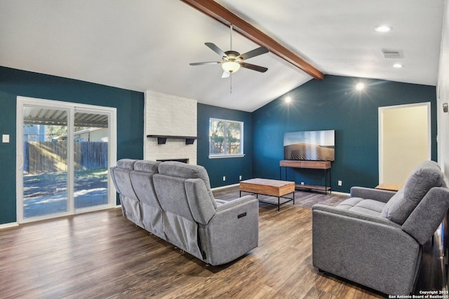 living room with lofted ceiling with beams, a brick fireplace, ceiling fan, and dark wood-type flooring