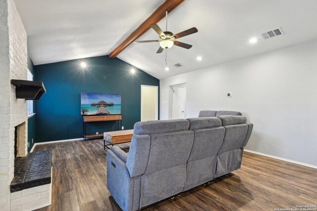 living room with a fireplace, vaulted ceiling with beams, dark hardwood / wood-style floors, and ceiling fan