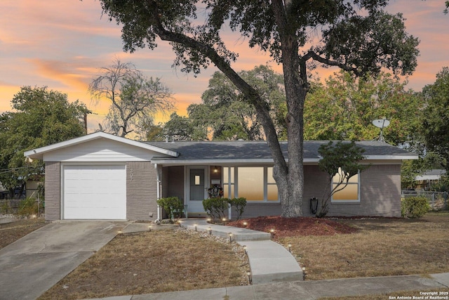 single story home featuring a lawn and a garage