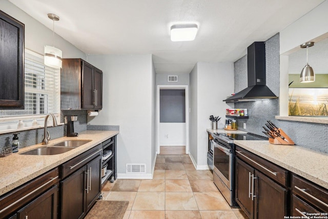 kitchen with sink, wall chimney exhaust hood, hanging light fixtures, and stainless steel electric range