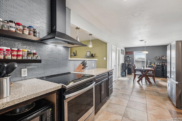 kitchen featuring decorative backsplash, appliances with stainless steel finishes, hanging light fixtures, and wall chimney range hood