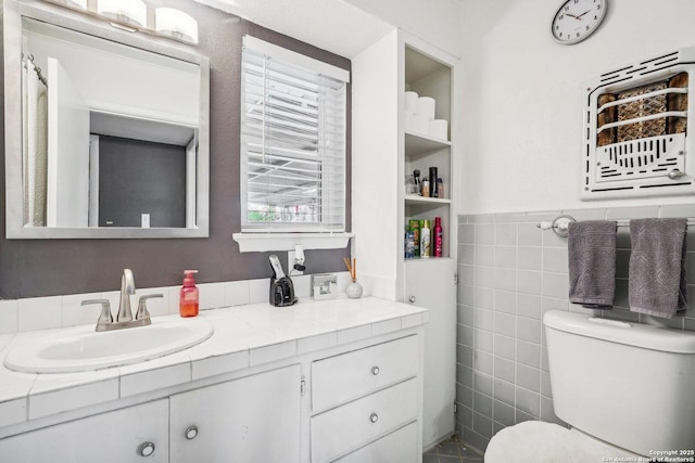 bathroom featuring vanity, toilet, and tile walls