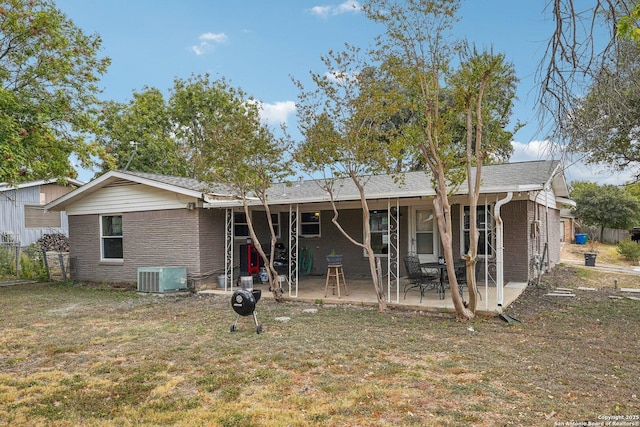 back of property with a patio, central AC, and a lawn