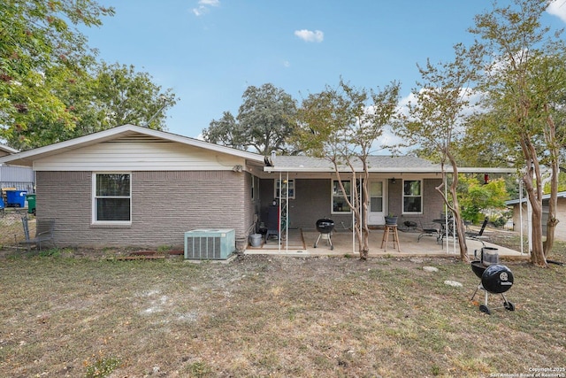 back of property featuring a lawn, cooling unit, and a patio