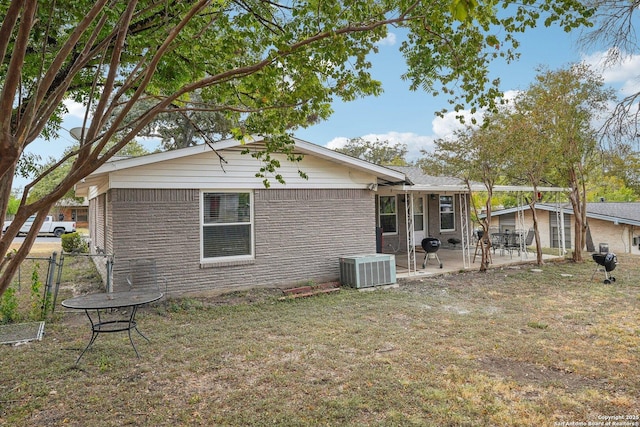 back of property with a yard and central AC unit