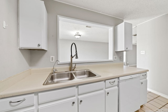 kitchen featuring white dishwasher, white cabinets, sink, light tile patterned floors, and a textured ceiling