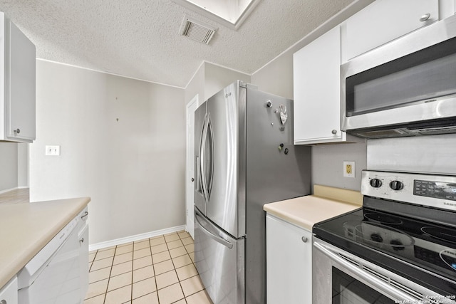 kitchen featuring white cabinets, light tile patterned floors, stainless steel appliances, and a textured ceiling