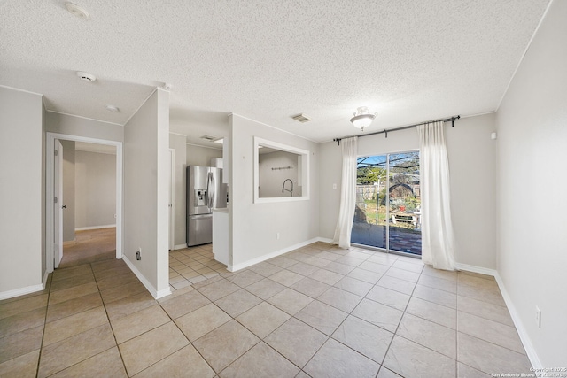 empty room featuring light tile patterned floors and a textured ceiling