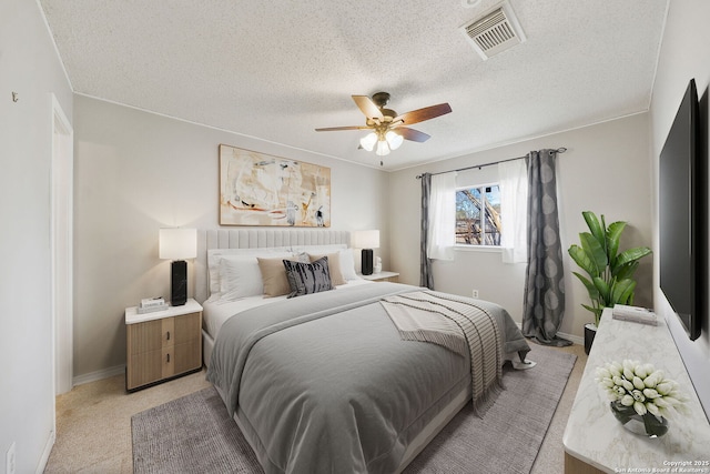 bedroom with ceiling fan, a textured ceiling, and light carpet