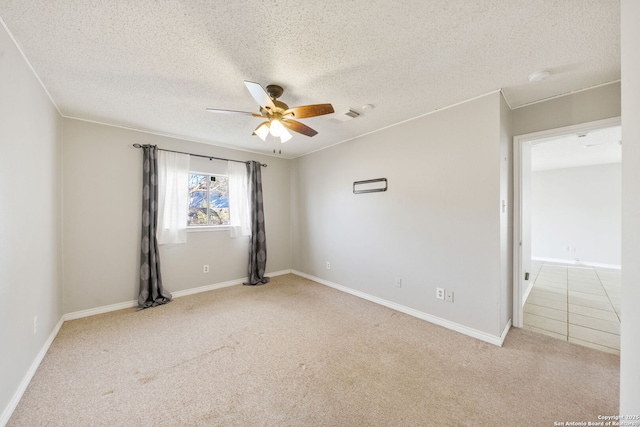 carpeted spare room with ceiling fan and a textured ceiling