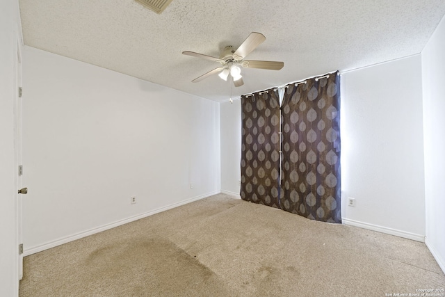 carpeted spare room featuring ceiling fan and a textured ceiling