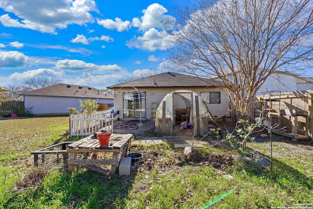 rear view of property featuring a lawn