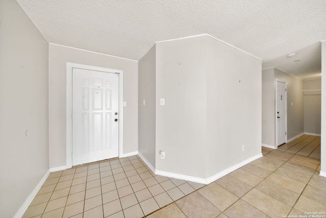 empty room with light tile patterned floors and a textured ceiling