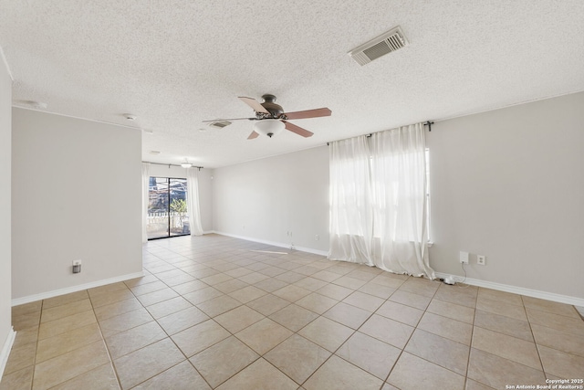 unfurnished room with ceiling fan, light tile patterned floors, and a textured ceiling