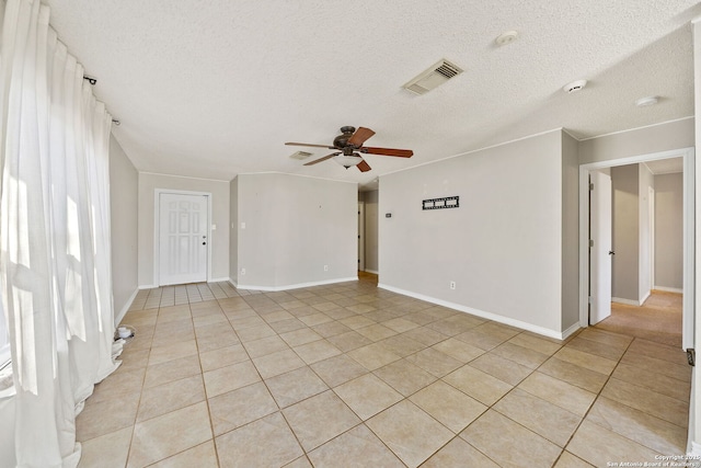 tiled empty room with ceiling fan and a textured ceiling