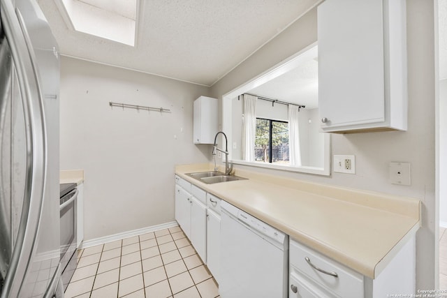 kitchen featuring stainless steel fridge, sink, light tile patterned floors, dishwasher, and white cabinetry