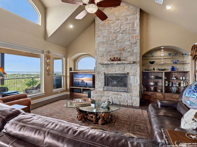 living room featuring a wealth of natural light, ceiling fan, a fireplace, and high vaulted ceiling