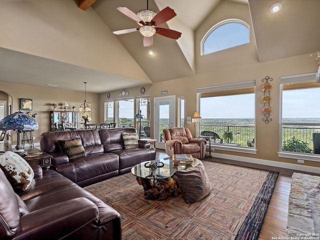 living room featuring ceiling fan, a wealth of natural light, wood-type flooring, and high vaulted ceiling