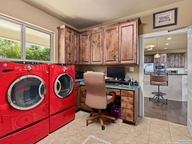 laundry area with light tile patterned floors, washer and dryer, and a textured ceiling